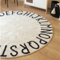 bawełniany dywan w kształcie koła z literami alfabetu wokół rantu