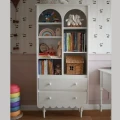 Wysoki regał Babushka biały marki Wood Luck Design z charakterystyczną ozdobną falbanką do pokoju dziecka