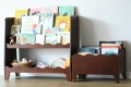 Drewniana biblioteczka dla malucha z otwartymi przegródkami ułatwiającymi samodzielny wybór książek.