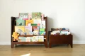 Ciemnobrązowa biblioteczka Montessori z czterema poziomami ekspozycji książek i zaokrąglonymi krawędziami